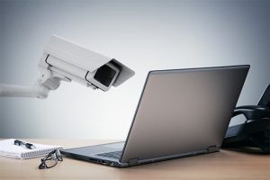 An image featuring internet privacy concept with a security camera pointing at a laptop