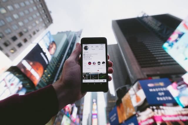 person holding turned on smartphone with tall buildings background
